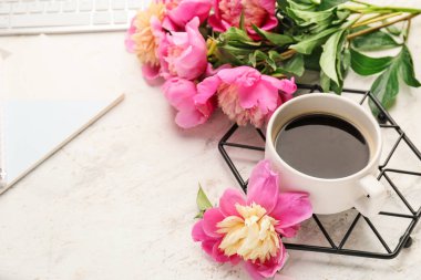 Güzel şakayık çiçekleri ve açık arkaplanda bir fincan kahve.
