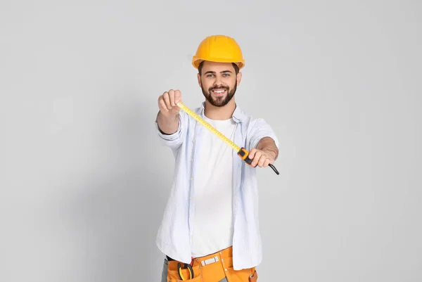 Young Man Measuring Tape Light Background — Stock Photo, Image