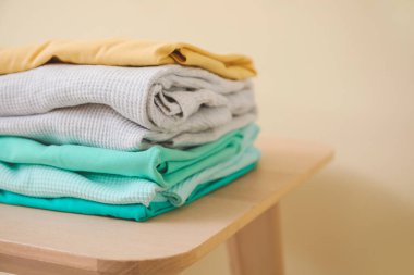 Dışkı üzerindeki temiz giysi yığını renk arkaplanına karşı, yakın plan