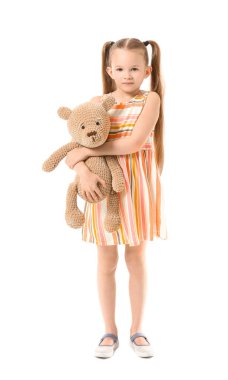 Beyaz arka planda oyuncak ayısı olan sevimli küçük bir kız.