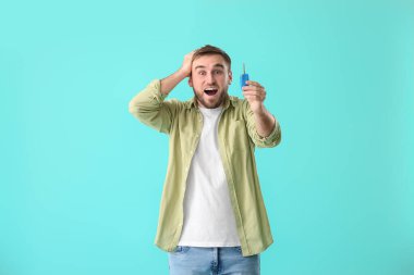 Arka planda araba anahtarı olan şaşırmış genç bir adam.