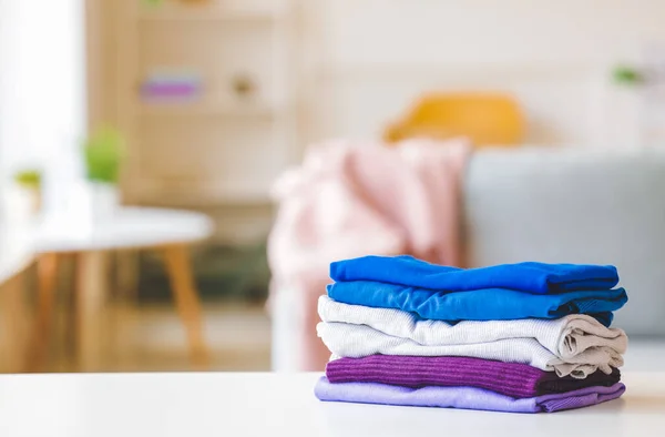 Stack of clean clothes on table in room