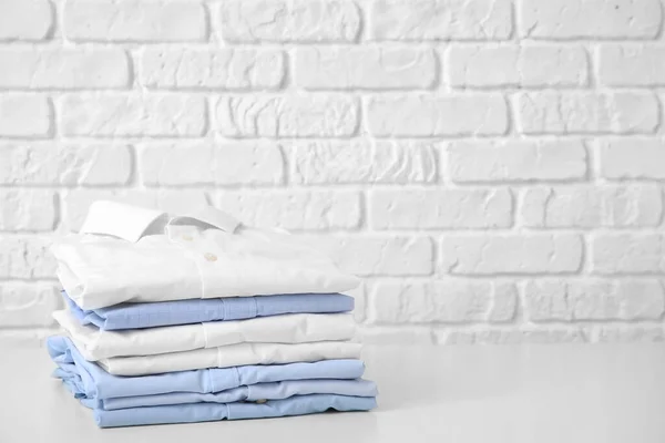 Stack Clean Clothes Table White Brick Background — Stock Photo, Image