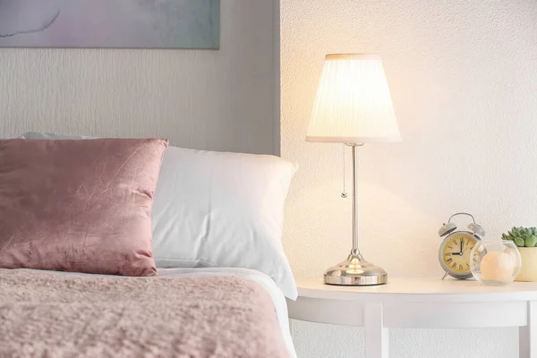 Modern lamp on table in bedroom