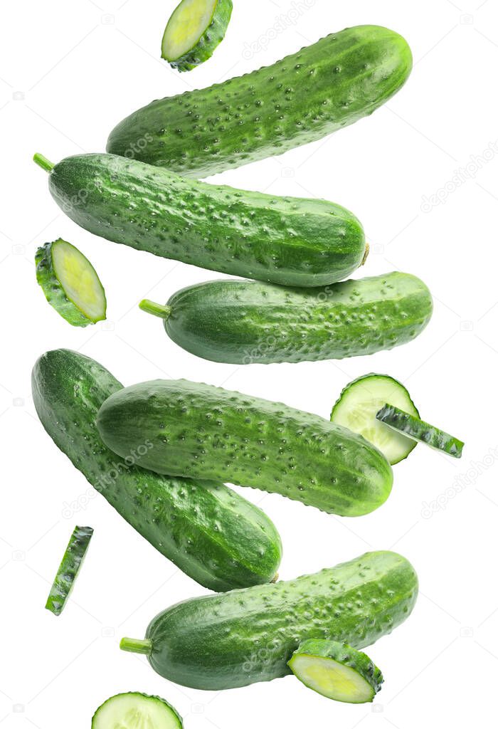 Flying green cucumbers on white background