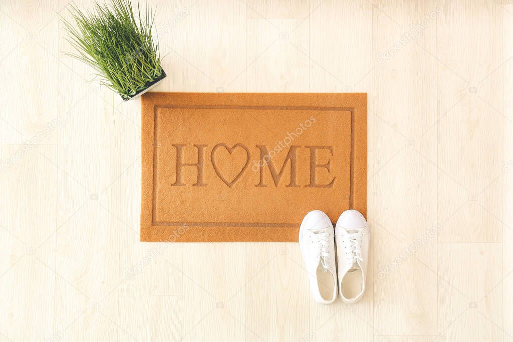 Door mat with shoes on wooden floor