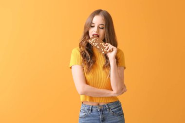 Renkli çikolata arkaplanlı güzel bir genç kadın.