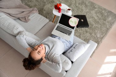 İş kadını hafta sonlarından önce kanepede dinleniyor.