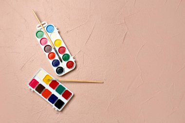 Renk arkaplanındaki boya ve fırçalar