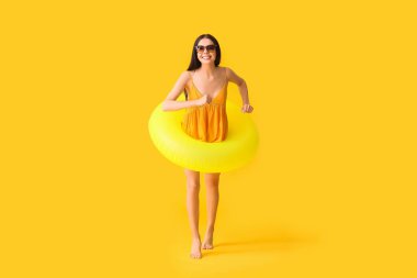 Renkli arka planda şişme yüzük ile genç kadın atlama