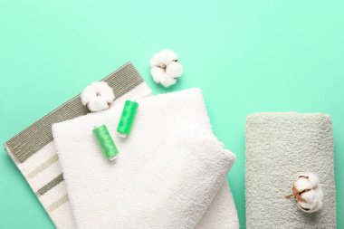 Renk arkaplanında pamuk, iplik ve yumuşak havlular