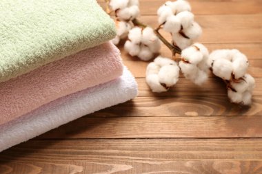 Ahşap arka planda pamuk çiçekler ve yumuşak havlular.