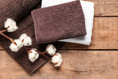 Ahşap arka planda pamuk çiçekler ve yumuşak havlular.