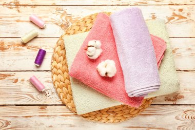 Tahta arka planda pamuk, iplik ve yumuşak havlular.
