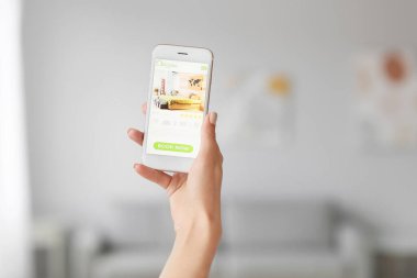 Otelde cep telefonu rezervasyon odası olan genç bir kadın.