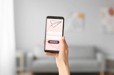 Cep telefonlu kadın turist internet üzerinden bilet alıyor.