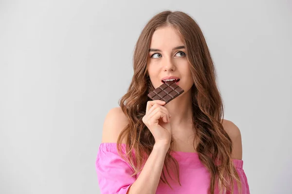 Beautiful Young Woman Tasty Chocolate Light Background — Stock Photo, Image