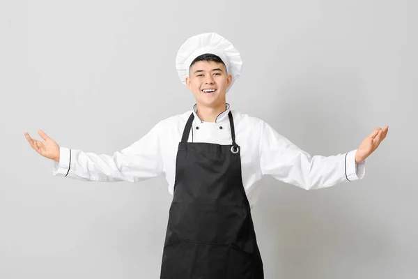 Bonito Chef Asiático Mostrando Algo Fundo Cinza — Fotografia de Stock