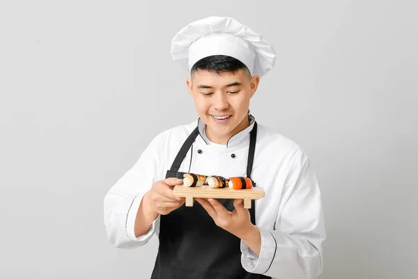 Guapo Chef Asiático Con Rollos Sushi Sobre Fondo Gris —  Fotos de Stock
