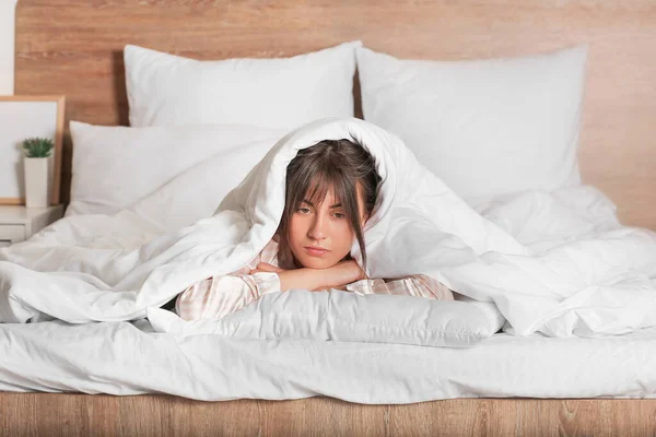 Young woman suffering from sleep deprivation in bedroom