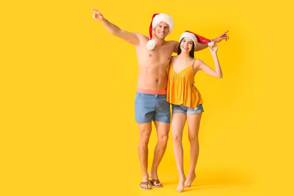 Young Couple Beachwear Santa Hats Color Background — Stock Photo, Image