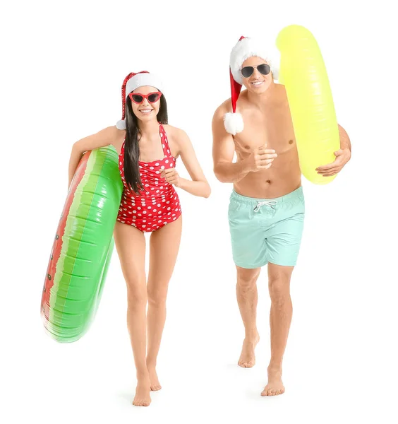 Running Young Couple Inflatable Rings Santa Hats White Background — Stock Photo, Image