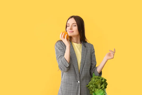 Junge Frau Hält Tasche Mit Lebensmitteln Auf Farbigem Hintergrund — Stockfoto