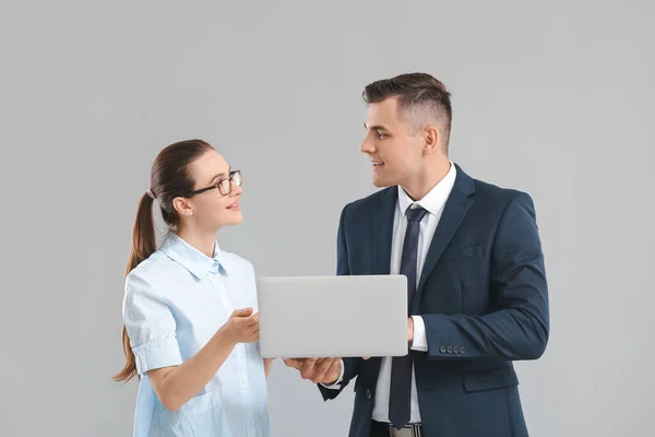 Jovens Empresários Com Laptop Fundo Cinza — Fotografia de Stock