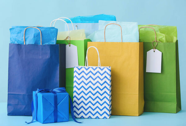 Paper shopping bags on color background