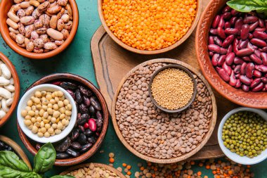 Renk arkaplanında baharat olan farklı ham baklagiller