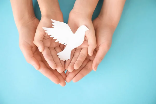 Renk Arkaplanında Kağıt Güvercin Olan Ailenin Elleri — Stok fotoğraf