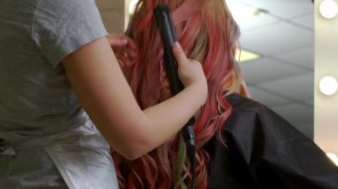 Kadın kuaför, kuaförde genç ve güzel bir bayanla çalışıyor.