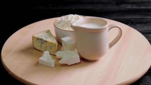 Drehbrett Mit Frischen Milchprodukten Auf Dunklem Holzgrund — Stockvideo