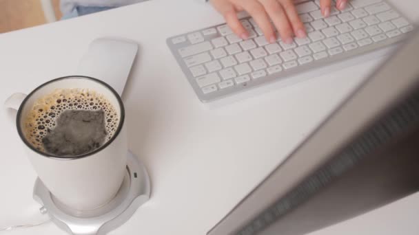 Kopje Koffie Met Verwarming Tafel Van Jonge Vrouw Werken Computer — Stockvideo