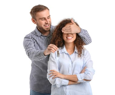 Beyaz arka planda anahtarı olan mutlu genç çift.