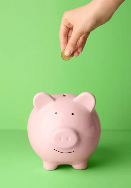 Mujer Poniendo Dinero Alcancía Sobre Fondo Color — Foto de Stock