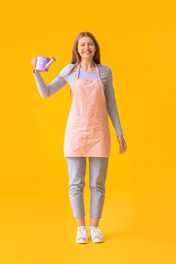 Renkli arka planda sulama kutusu olan genç kadın