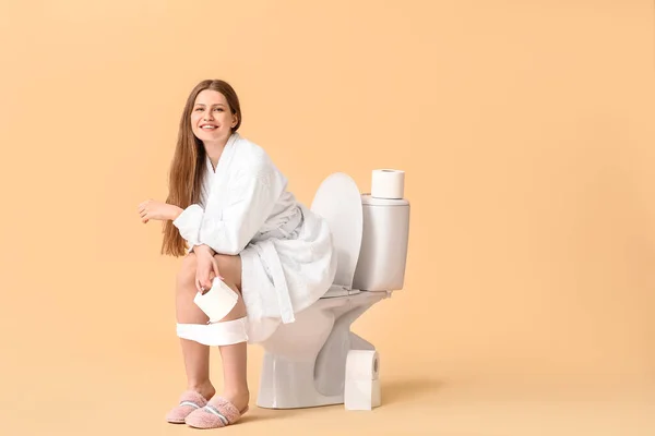 Jovem Mulher Sentada Vaso Sanitário Contra Fundo Cor — Fotografia de Stock