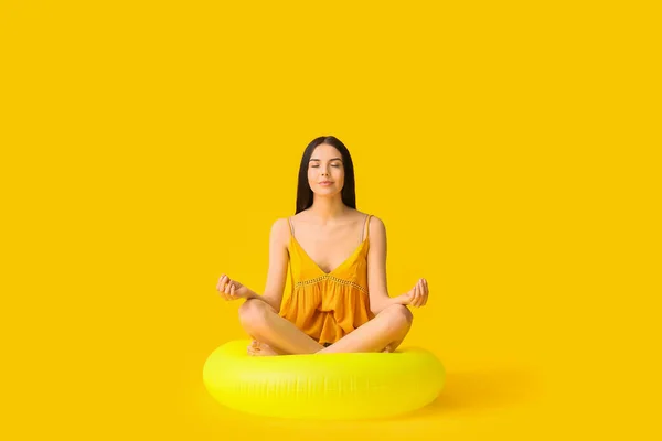 Mujer Joven Meditando Con Anillo Inflable Sobre Fondo Color —  Fotos de Stock