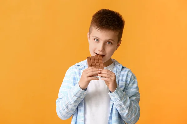 Cute Little Boy Eating Chocolate Color Background — Stock Photo, Image