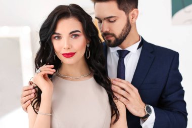 Evin içinde şık aksesuarlar giyen genç bir çift.