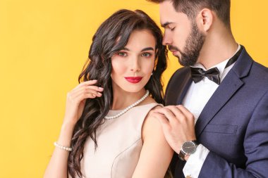 Renkli arka planda şık aksesuarlar giyen genç çift
