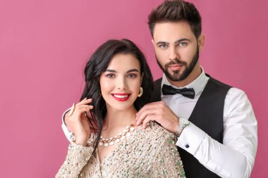 Renkli arka planda şık aksesuarlar giyen genç çift