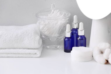 Cosmetics and supplies on table in bathroom clipart