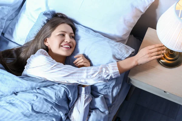 Young Woman Turning Light While Lying Bed Night — Stock Photo, Image