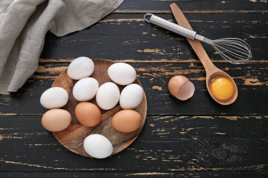 Taze tavuk yumurtası, çırpma ve kaşık ahşap arka planda