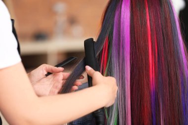 Kuaför, güzellik salonunda genç bir kadınla çalışıyor.