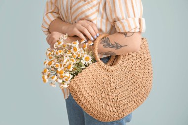 Gri arka planda güzel papatyaları olan bir kadın