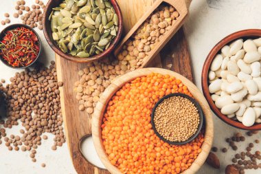 Beyaz arkaplanda farklı ham baklagiller ve baharatlar