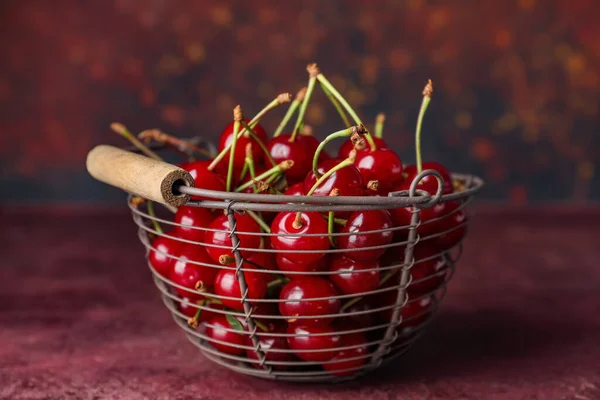 Basket with sweet cherry on table